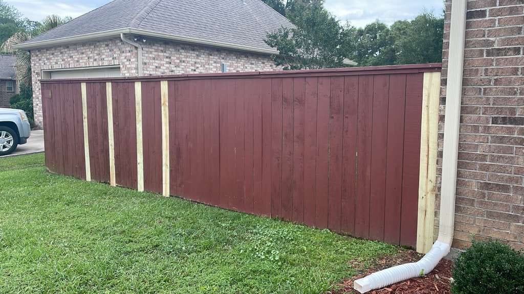 Painted wood fence repaired with new pickets
